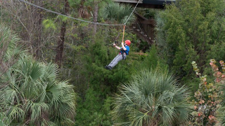 Boy riding on a zipline at Gatorland theme park in Orlando, Florida