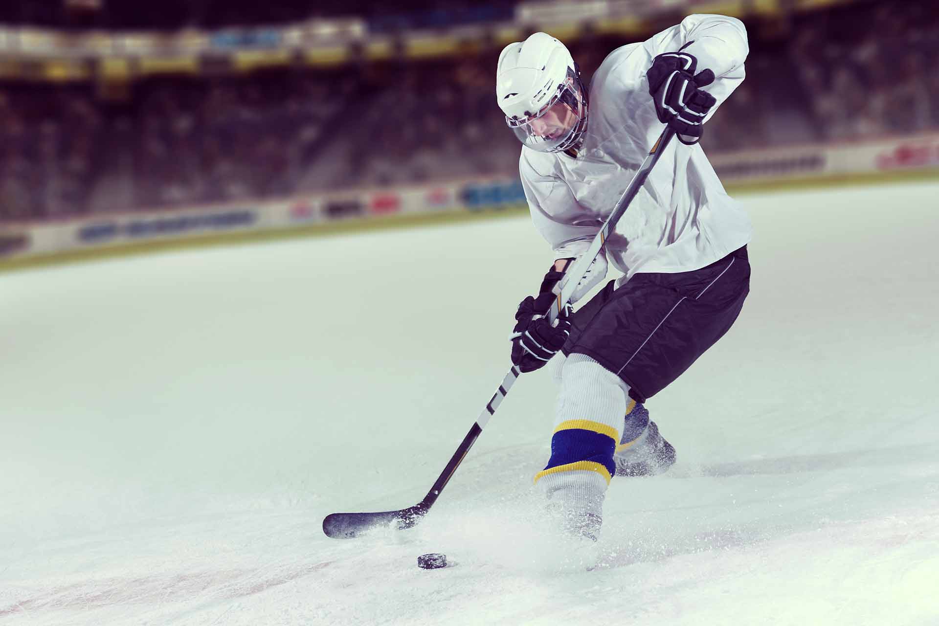 Ice hockey player about to hit the puck