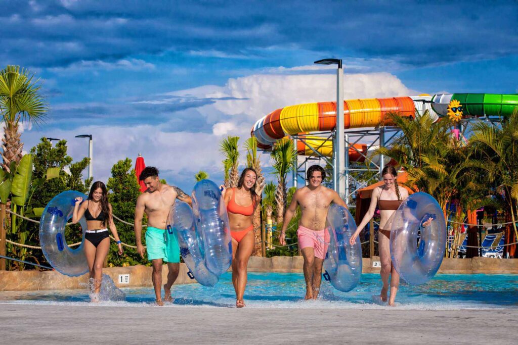 Group of friends carrying tubes out of a pool at Island H2O Water Park