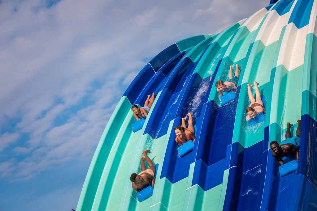 Group of people racing down the Reply Racers water slide at Island H2O Water Park