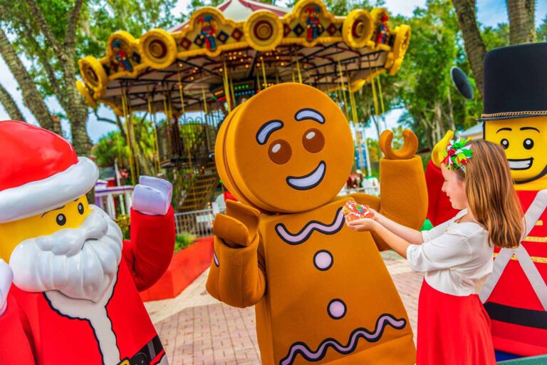 Girl giving a cookie to the LEGOLAND Gingerbread Man - LEGOLAND Florida