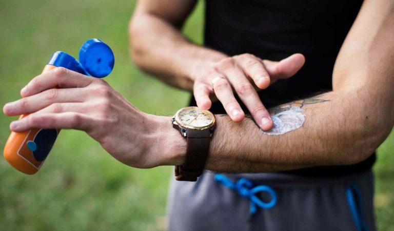 Man applying sunscreen on his arm