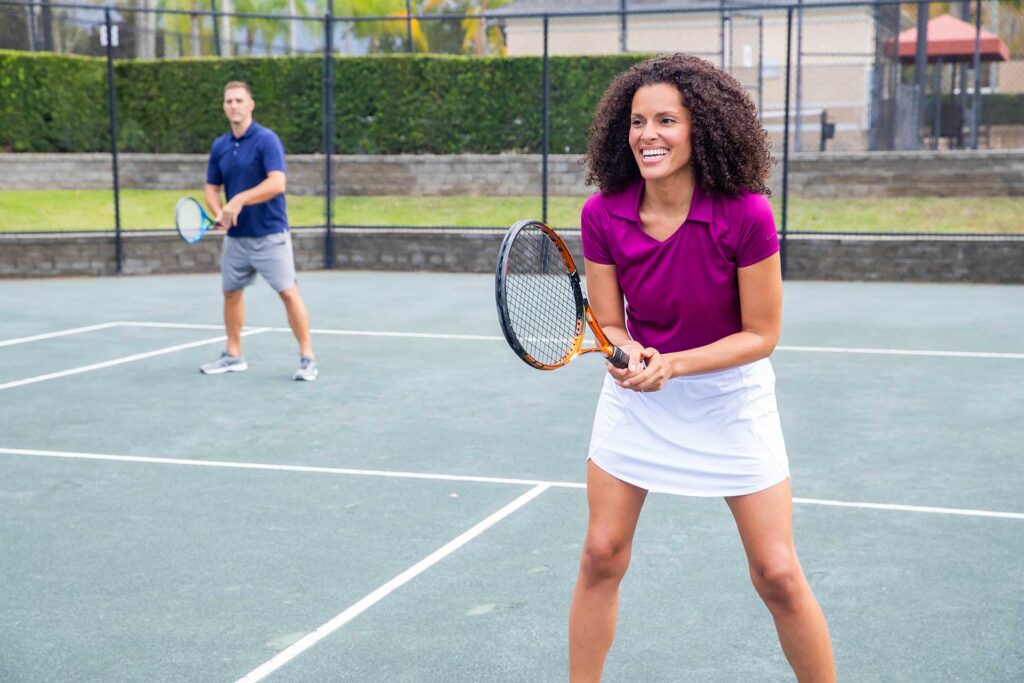 Couple playing doubles tennis at the Reunion Resort tennis courts