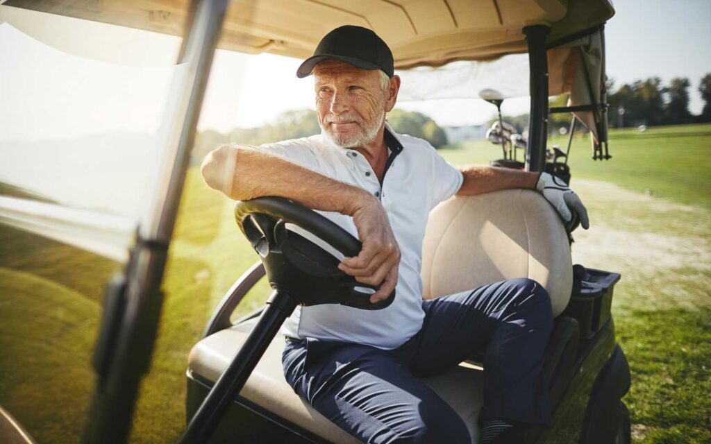 Older man driving a golf cart at Reunion Resort