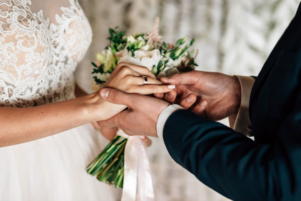 Bride and groom exchange wedding rings.